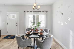 Dining space featuring light wood finished floors and a chandelier