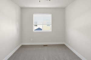 Spare room with light colored carpet and baseboards