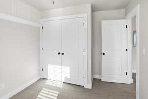 Unfurnished bedroom featuring carpet and a closet