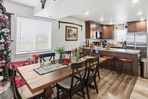 Dining room featuring healthy amount of natural light, light wood finished floors, and recessed lighting