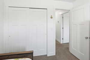 Unfurnished bedroom with a closet and dark carpet