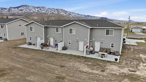 Rear view of house featuring a patio, a mountain view, and a residential view