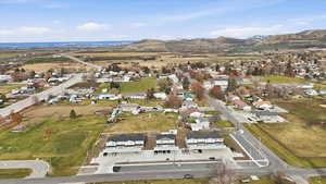 Aerial view of property and surrounding area featuring a mountainous background and nearby suburban area