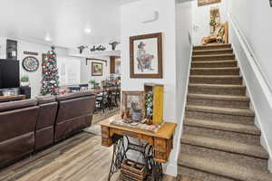Staircase with wood finished floors and recessed lighting