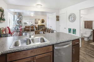 Kitchen featuring dishwasher, dark wood-style flooring, open floor plan, and light countertops