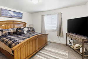 Bedroom featuring light colored carpet and baseboards