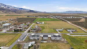 Aerial overview of property's location featuring rural landscape, extensive farmland, and a mountain backdrop