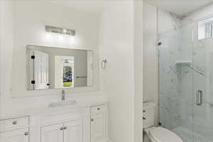 Full bath featuring a marble finish shower and vanity