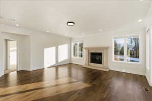 Unfurnished living room with a fireplace, dark wood-style floors, crown molding, and recessed lighting