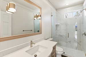 Bathroom featuring vanity and a marble finish shower