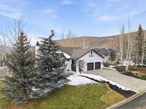 View of front facade with a chimney, driveway, and a front yard