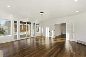 Empty room featuring french doors, crown molding, dark wood-style floors, and recessed lighting