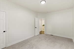 Empty room featuring carpet and baseboards