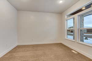 Empty room with light carpet and baseboards