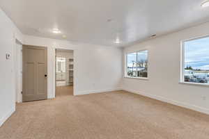 Unfurnished room with light colored carpet and baseboards