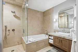 Full bath featuring vanity, a shower stall, and a garden tub