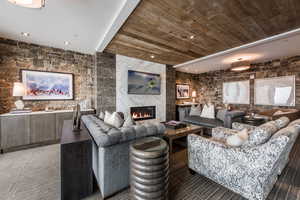 Living area with a fireplace, wooden ceiling, and recessed lighting