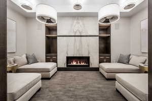 Living room featuring built in features and a premium fireplace