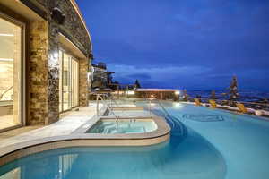 Community pool featuring a patio and a hot tub