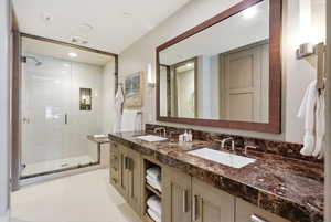 Bathroom featuring double vanity, a shower stall, recessed lighting, and light tile patterned floors