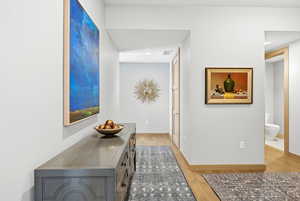Corridor featuring light wood finished floors and baseboards