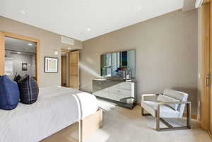 Bedroom with light colored carpet and recessed lighting