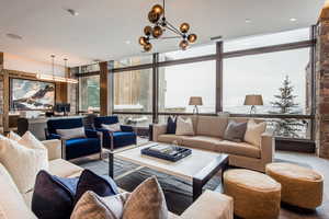 Living area with healthy amount of natural light, expansive windows, and a chandelier