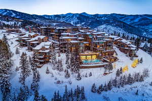 Snowy aerial view featuring a mountain view and a residential view