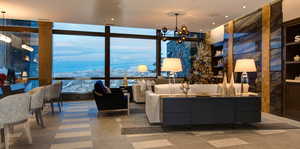 Living room with floor to ceiling windows, a chandelier, and recessed lighting