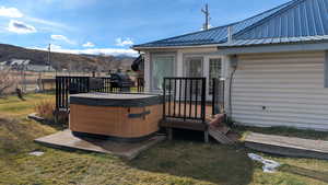 Wooden deck featuring a hot tub, a mountain view, and a grill. View looking Southwest.