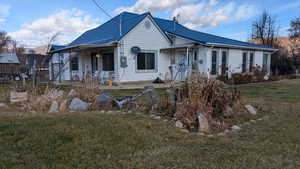 View of front of house featuring a front lawn and a metal roof. View looking East.