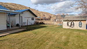 View of yard featuring a mountain view, garage/workshop, and outbuildings. View facing Northwest.