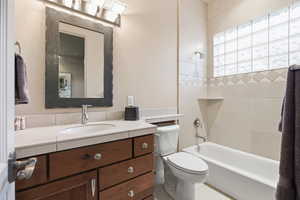 Bathroom featuring vanity, washtub / shower combination, and tile patterned flooring
