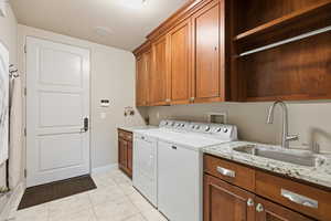 Laundry room with cabinet space, separate washer and dryer, and light tile patterned flooring