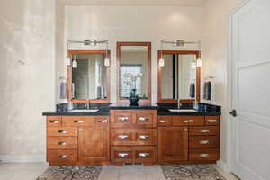 Full bathroom with double vanity and light tile patterned flooring