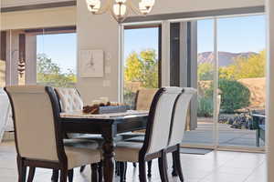 Dining room with light tile patterned floors, a chandelier, and a mountain view