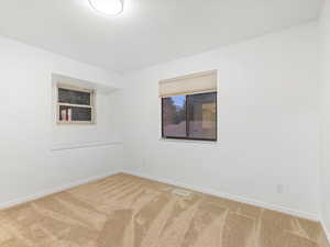 Carpeted spare room featuring baseboards and a textured ceiling