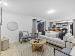Living area with baseboards and light wood finished floors