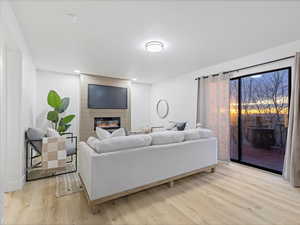 Living room with a fireplace and light wood-style floors
