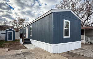 View of home's exterior featuring entry steps and a storage shed