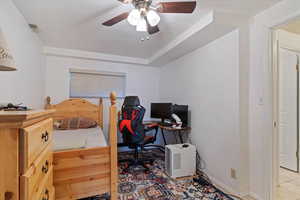 Bedroom featuring a ceiling fan, a textured ceiling, and a desk
