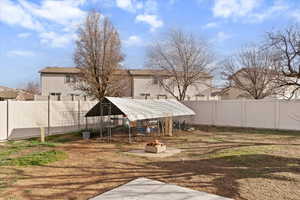 Fenced backyard with a patio area, an outdoor structure, and an exterior structure