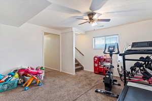 Workout area featuring a textured ceiling, carpet, and ceiling fan