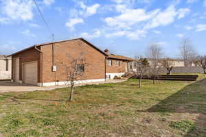 View of property exterior featuring brick siding and concrete driveway