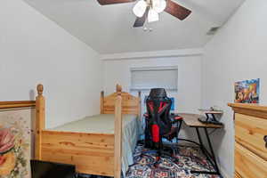 Bedroom with a textured ceiling and ceiling fan