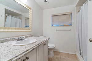 Bathroom featuring a shower with shower curtain, vanity, light tile patterned flooring, and a textured ceiling