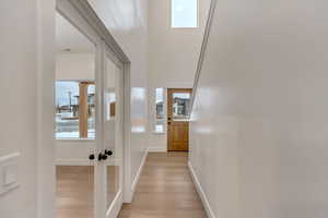 Hall featuring light wood-type flooring and baseboards