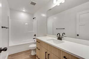 Full bathroom with shower / tub combination, vanity, and light wood-style floors