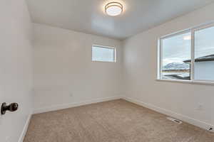 Spare room with light colored carpet and baseboards