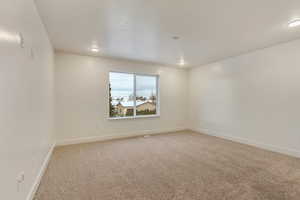 Unfurnished room with light colored carpet and baseboards